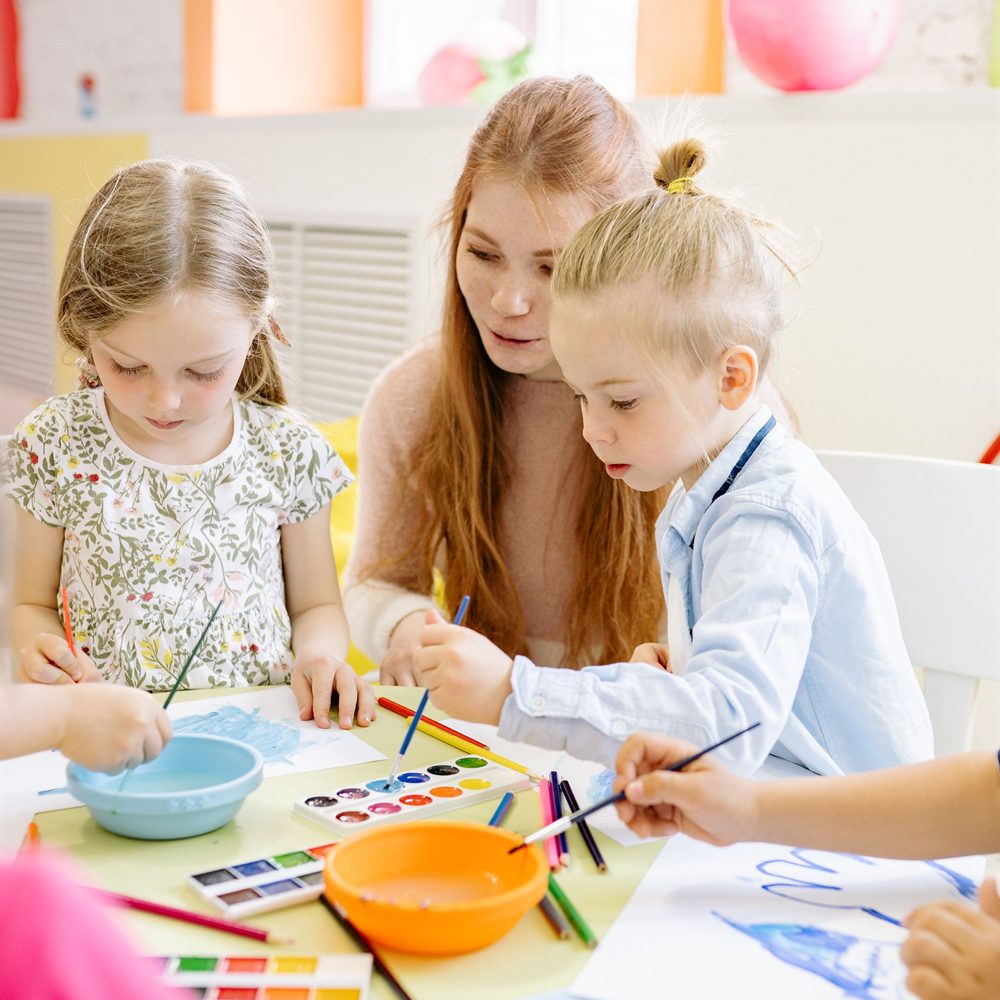 Children painting with watercolours around a table