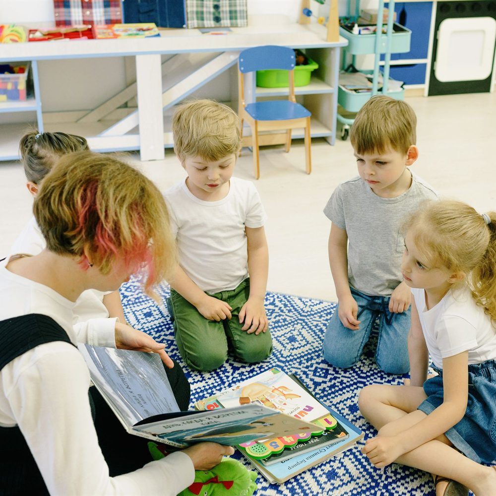 Children sitting on the mat reading books together