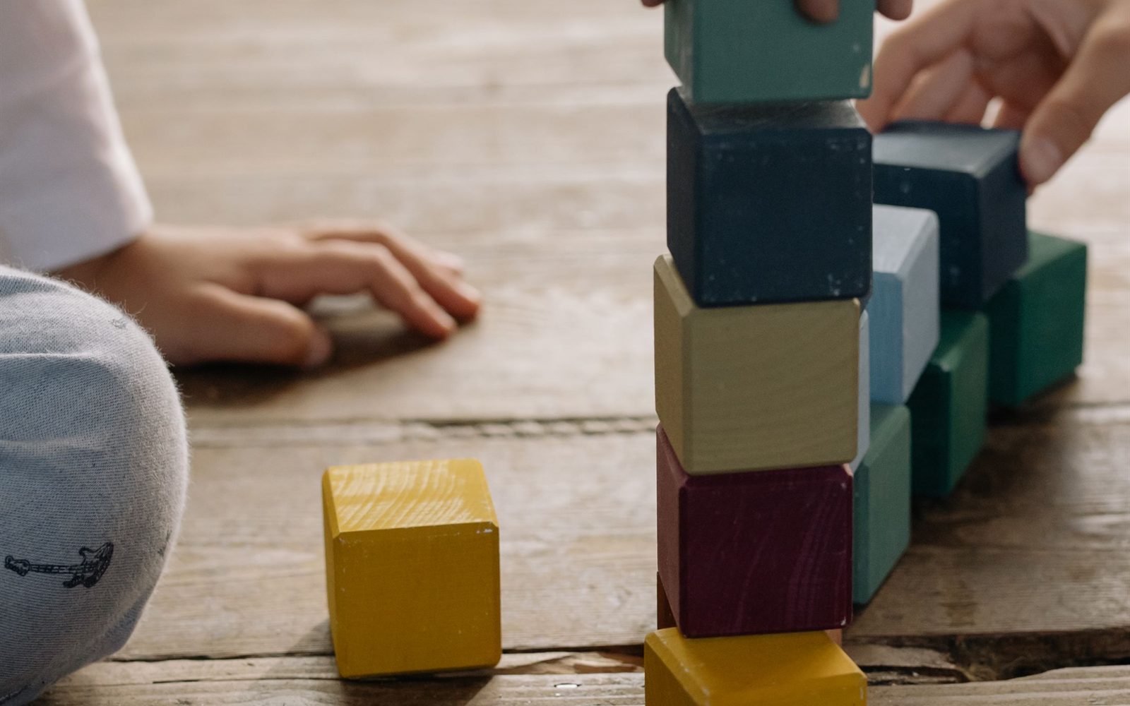 Children building together with wooden blocks on the floor