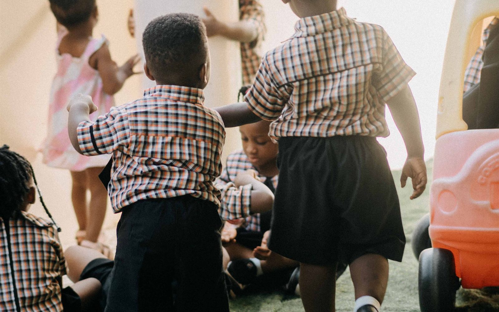 Preschoolers playing together outside on the school's lawn